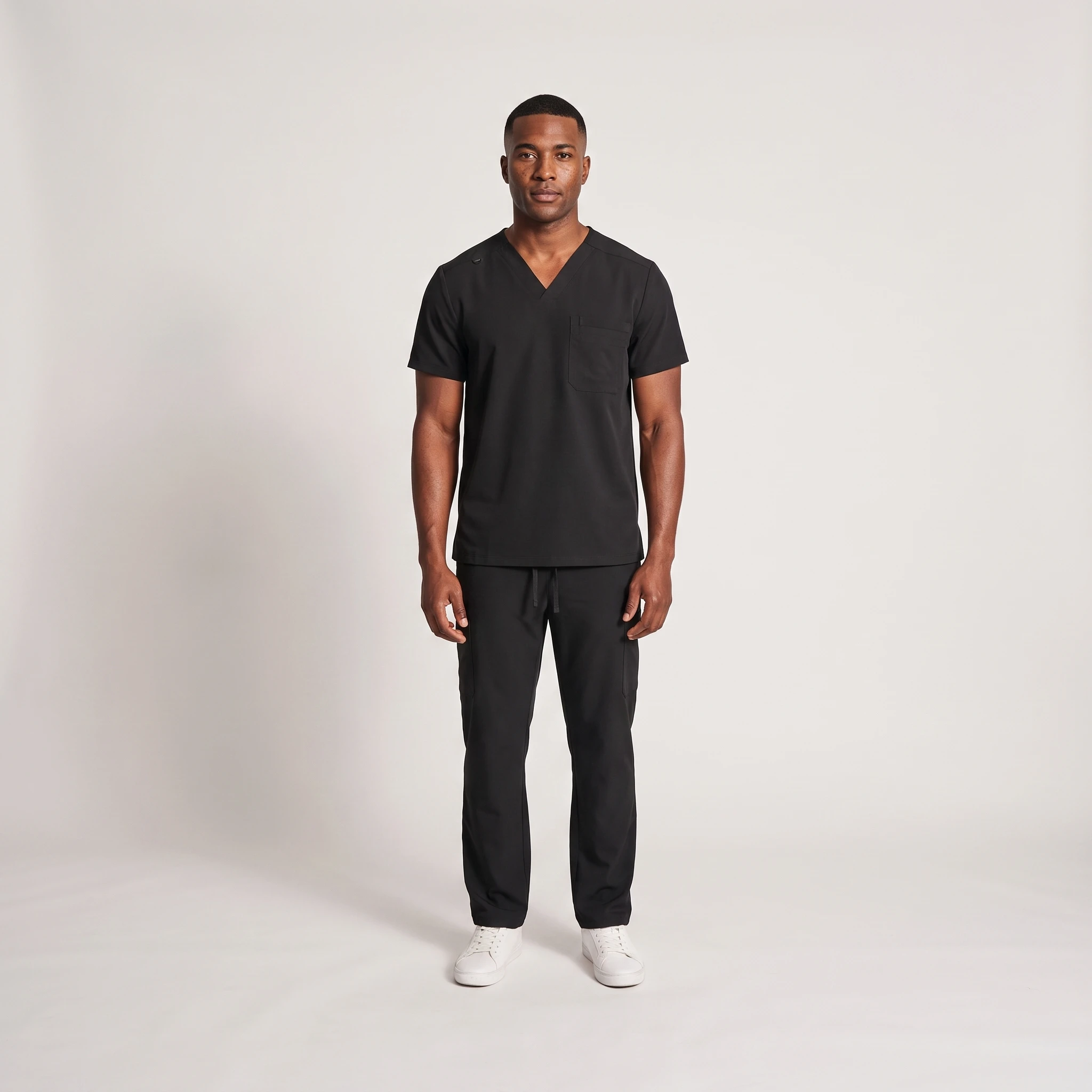 Men's Lumi Core Scrubs — Black, model wearing V-neck top and straight-leg pants