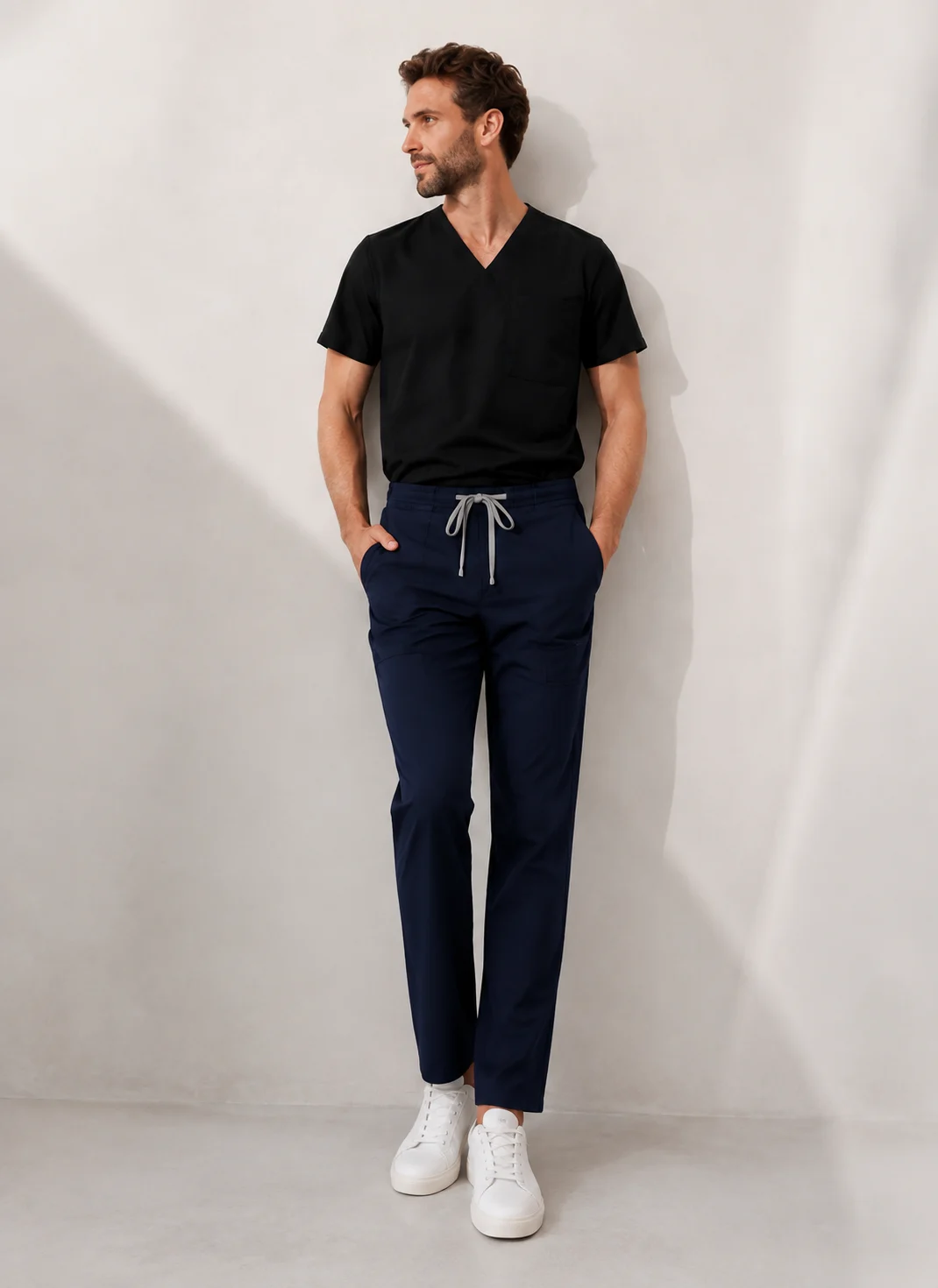 Black scrub top and navy pants in soft window light