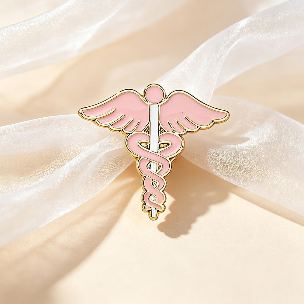 Pink winged caduceus enamel pin with a gold outline