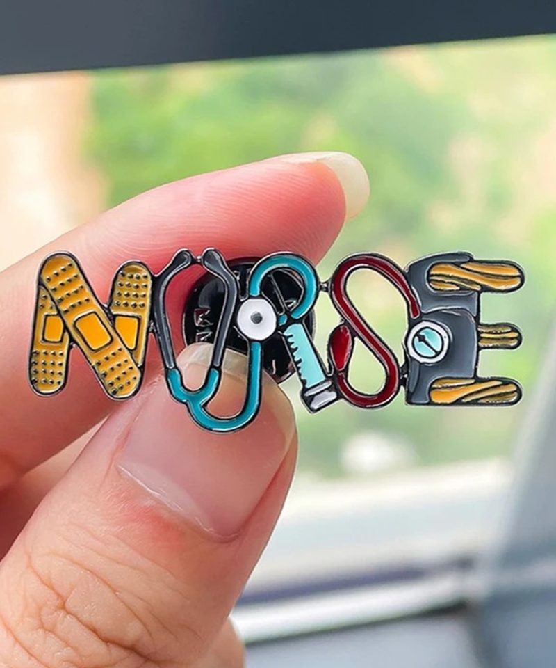 NURSE enamel pin held between two fingers