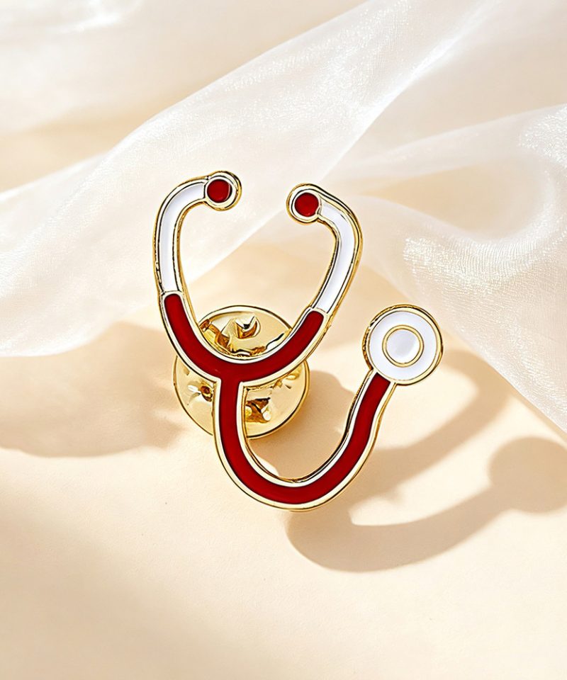 Red and white stethoscope enamel pin with a gold outline